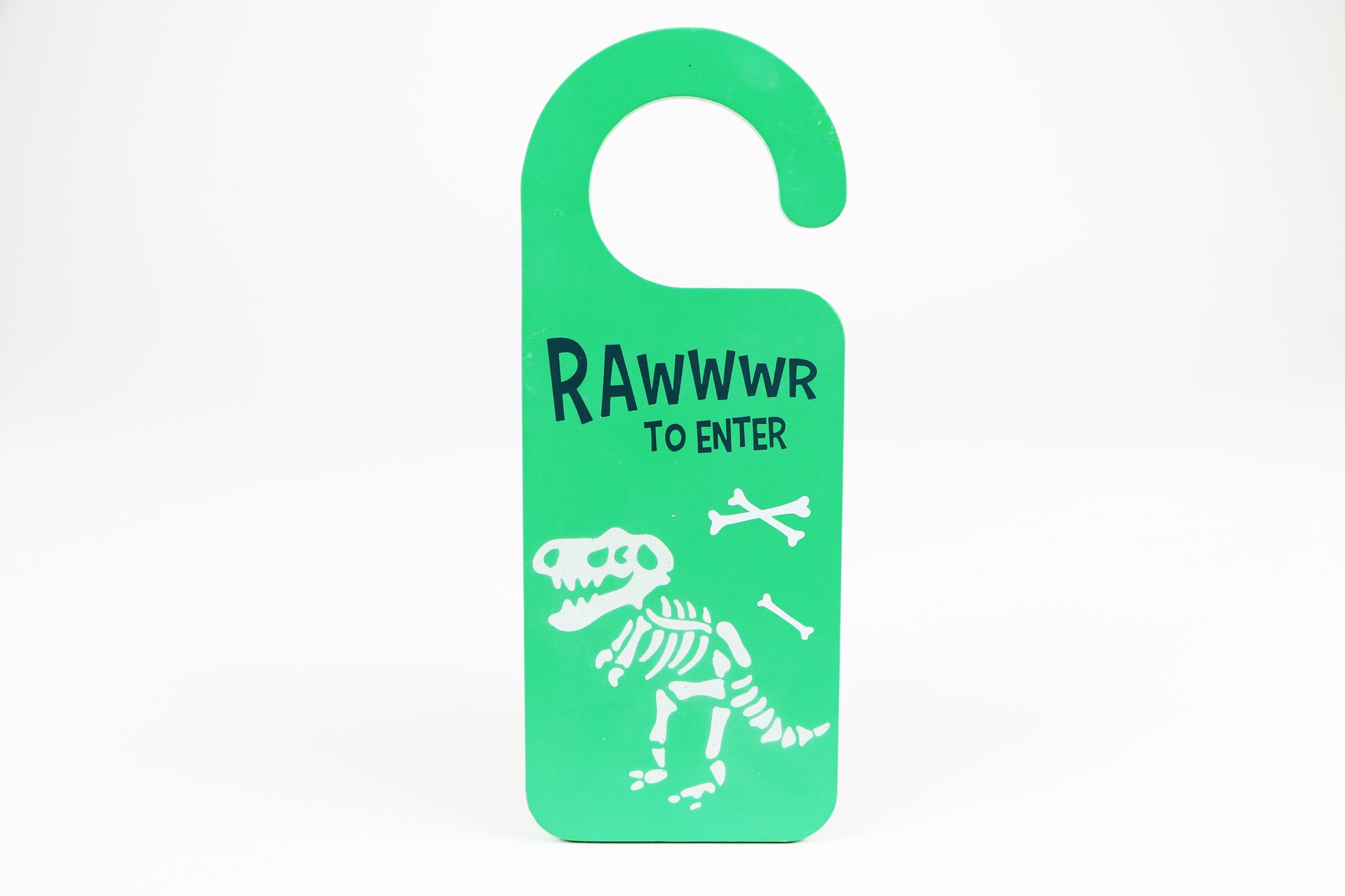 Door Hanger  This MDF door hanger features a ferocious, glow in the dark t-rex skeleton that is sure to be a hit with boys and girls alike. ‘Rawwwr to Enter’ text adds a fun touch to this wild style. 